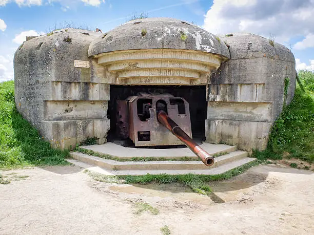 German defense battery against allied troops debarquement, bunker ruins with rusty gun at Longues sur Mer, Normandy, France.