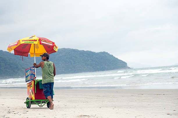 Ubatuba, Brazil - January 15, 2015: A guy selling ice creams on the beach (Itamambuca Beach).