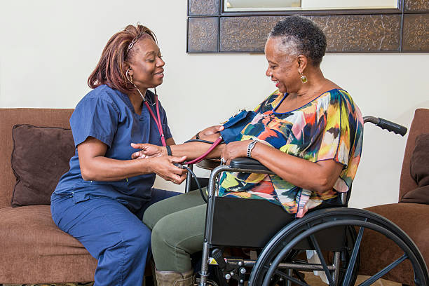Home Healthcare Worker Assists Senior Woman stock photo