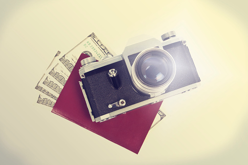Passport, camera and money in retro-styled