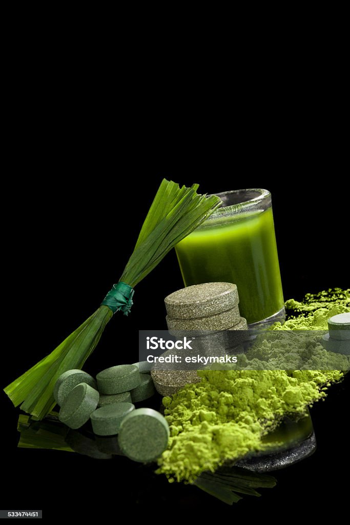 Detox. Green food supplements. Chlorella, spirulina, wheat grass and young barley isolated on black background. Green superfood, healthy eating, alternative medicine and detox. 2015 Stock Photo