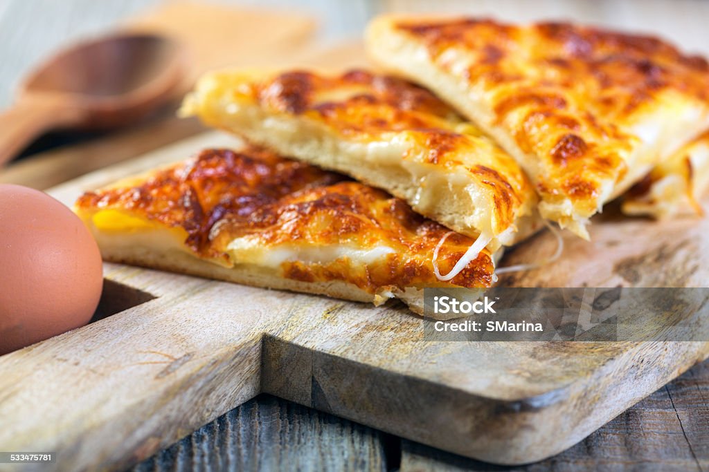 Pieces of cheese pie. Pie with cheese on a wooden board close up. 2015 Stock Photo