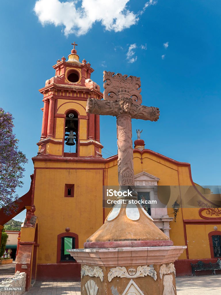 Beautiful Church of Bernal with crucifix The main square with its colonial church in the town of Bernal, State of Queretaro, Mexico. Bernal is a Pueblo Magico - a magic town, a title given to particularly beautiful romantic towns in Mexico. 2015 Stock Photo