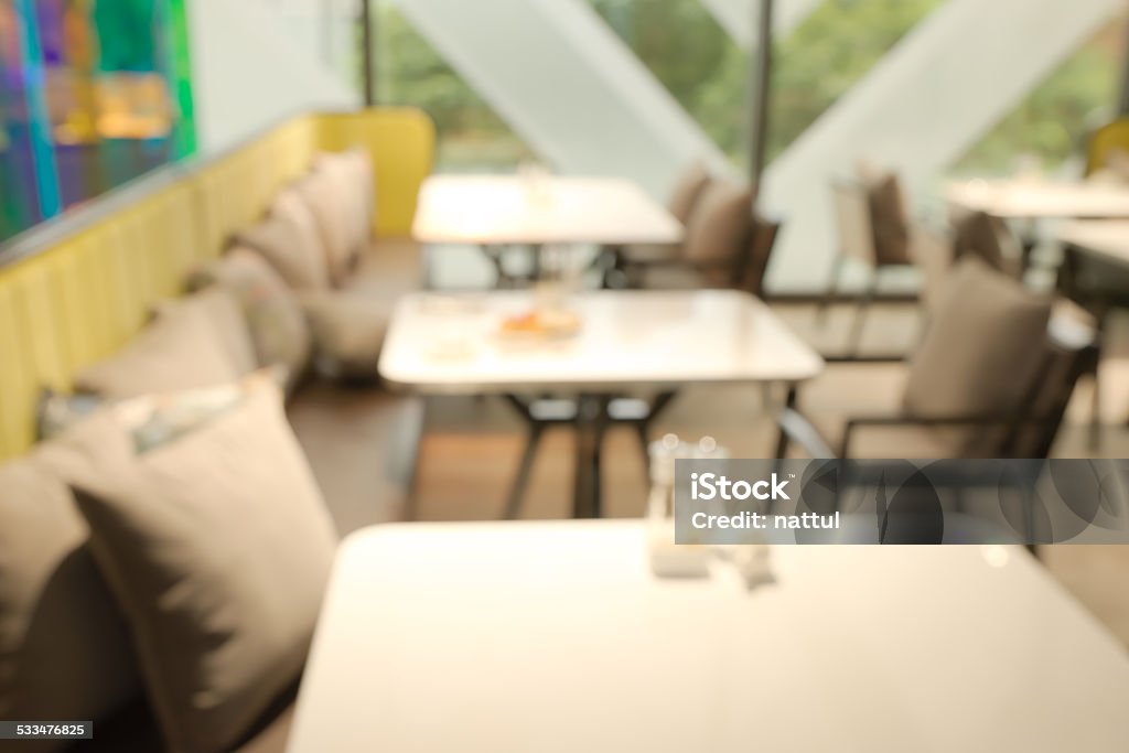 Abstract blurry restaurant Abstract blurry restaurant with blurry green large tree visible outside windows in background 2015 Stock Photo