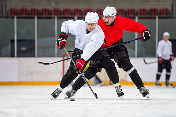 two ice hockey players dueling - ijshockey mannen fotos stockfoto's en -beelden