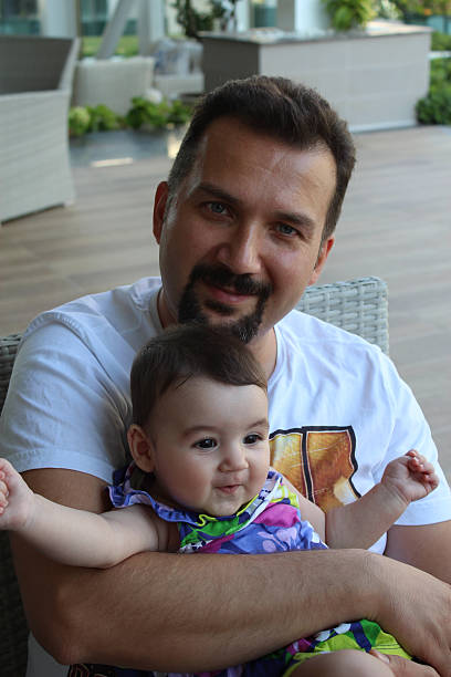 istock father holding baby 533497569
