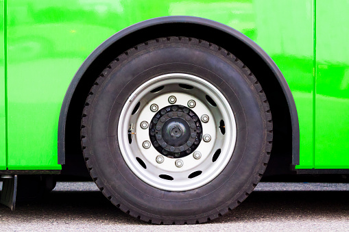 Closeup green bus wheel, full frame horizontal composition with copy space