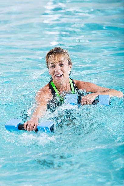 istock Middle-aged  woman in pool doing water aerobics 533517879