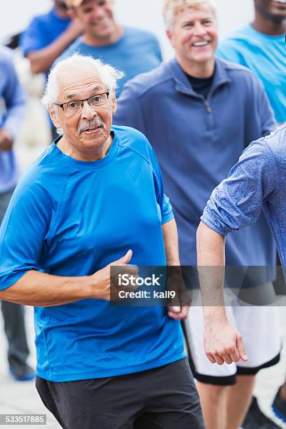 Hispanic Senior Man Running With Group Stock Photo - Download Image Now - 2015, 70-79 Years, Active Lifestyle
