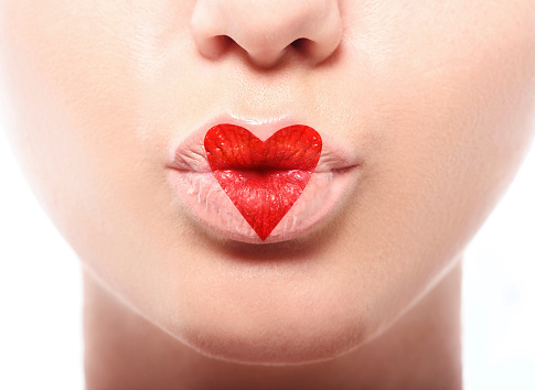 Kissing lips with lovely red make up at the heart shape. Valentines day concept. Studio macro shot. High resolution