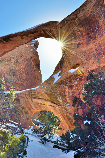 Sun rays coming through the Double-O-Arch in Devil's Garden in Arches National Park, Utah in winter, HDR