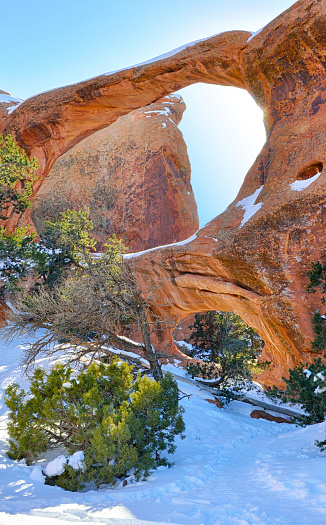 Sun rays coming through the Double-O-Arch in Devil's Garden in Arches National Park, Utah in winter, HDR