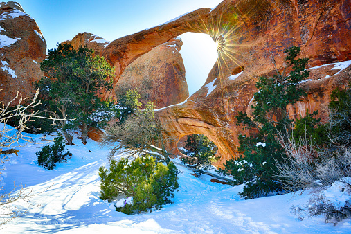 Sun rays coming through the Double-O-Arch in Devil's Garden in Arches National Park, Utah in winter, HDR