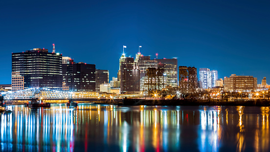 Newark, NJ cityscape by night, viewed from Riverbank park. Jackson street bridge, illuminated, spans the Passaic River