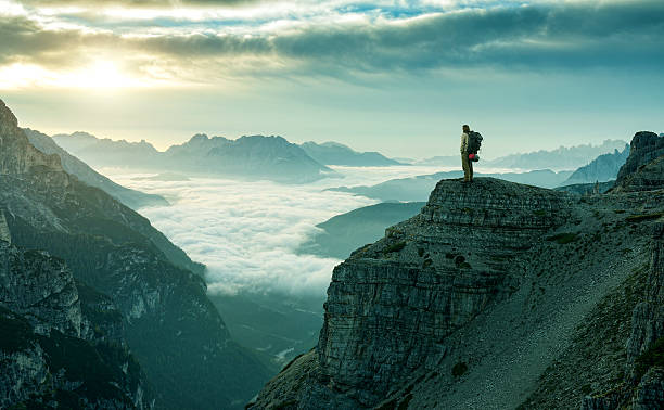caminhante homem na rocha cliff - mountain sunrise scenics european alps - fotografias e filmes do acervo