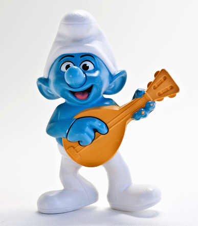 Cairo, Egypt- December 29th 2011 : Smurf character from The Smurf movie. It is a plastic toy. The smurf character acts as a musician and holding an orange guitar.
