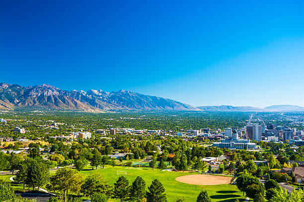 Salt Lake City skyline aerial view with mountains and park Salt Lake City aerial skyline view with a park in the foreground, downtown to the right, and the Wasatch Range mountain range far in the distance. salt lake city utah stock pictures, royalty-free photos & images