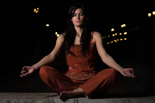istock Beautiful woman practicing meditation at night 533555206
