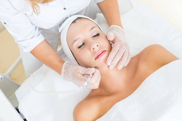 Microdermabrasion treatment Young woman receiving facial microdermabrasion treatment microdermabrasion stock pictures, royalty-free photos & images