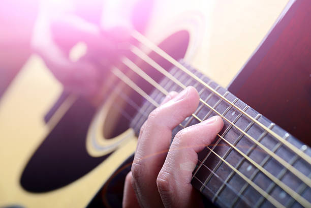 istock man's hands playing acoustic guitar, close up 533558173