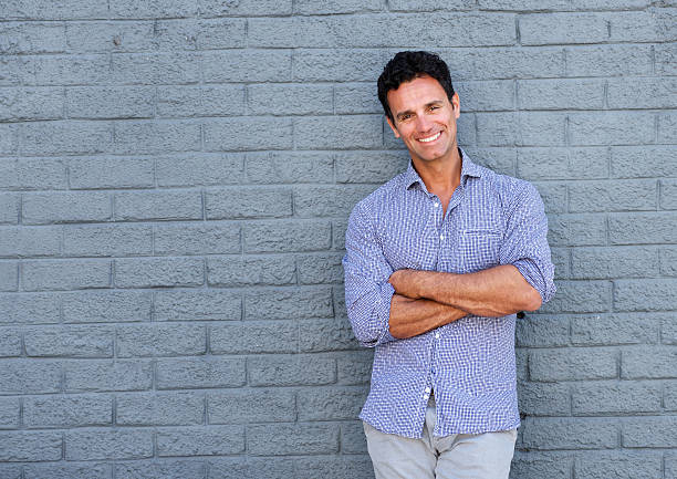 istock Handsome older man smiling with arms crossed 533559722