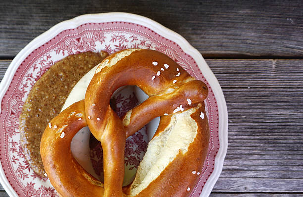 Weisswurst with homemade Pretzel Weisswurst with homemade Pretzel on timber table twisted bacon stock pictures, royalty-free photos & images