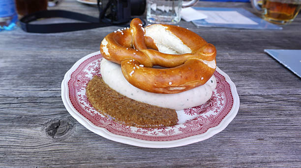 Weisswurst with homemade Pretzel Weisswurst with homemade Pretzel on timber table twisted bacon stock pictures, royalty-free photos & images