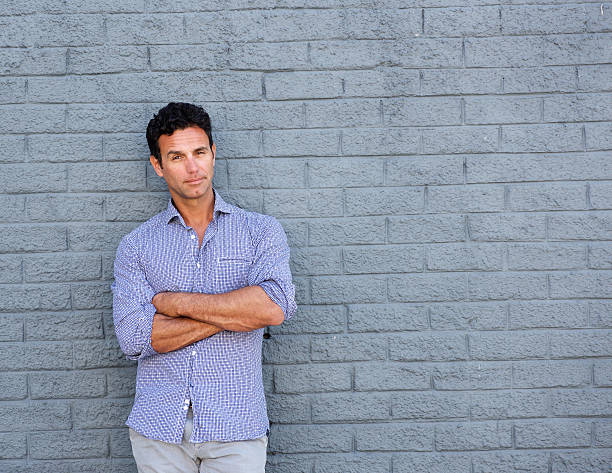 istock Handsome man standing with arms crossed 533562656