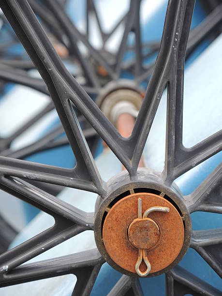 Wheel Axle with Hub Close up of the hub of an upside down wheelbarrow with axle showing in background. linchpin stock pictures, royalty-free photos & images