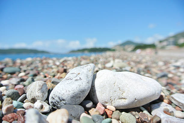 istock Closeup of white stones on pebbly beach; blue sky 533566148