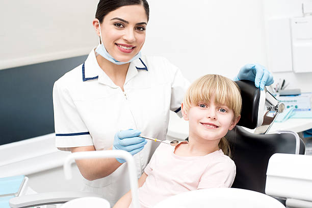 istock Professional dentist posing with girl child 533566338