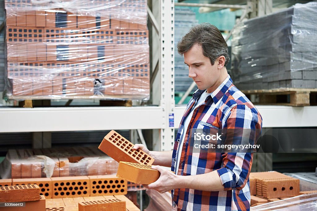 Man chooses building brick in store Man chooses a building brick in the store Construction Industry Stock Photo
