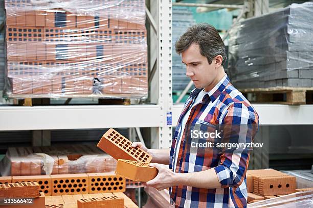 Man Chooses Building Brick In Store Stock Photo - Download Image Now - Construction Industry, Men, Merchandise