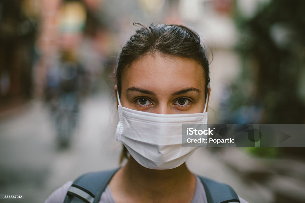 Young woman with face mask in the street Young woman wearing face mask in the street. Protective Face Mask Stock Photo