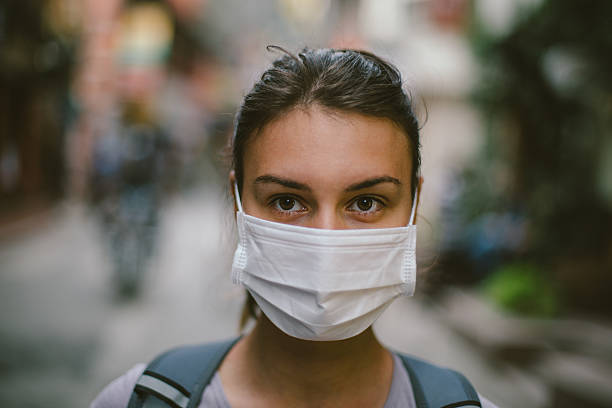 Young woman with face mask in the street Young woman wearing face mask in the street. avian flu virus photos stock pictures, royalty-free photos & images