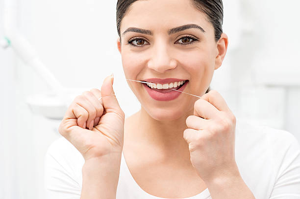 istock Woman cleaning her teeth by dental floss 533567648