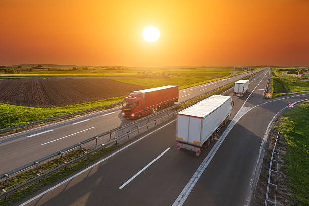 istock Speed delivery trucks on the empty highway at sunset 533571178