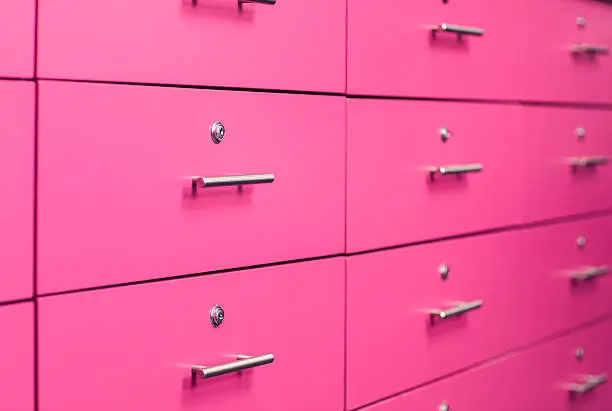 Close up locked pink drawers wall for things storage.