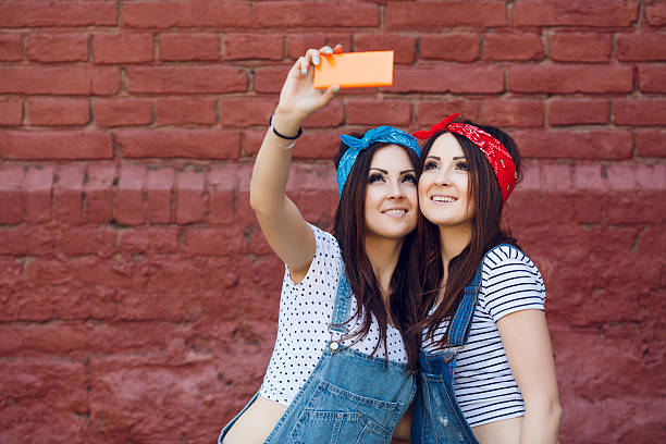 istock twins girls doing selfie 533573646
