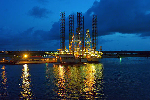 impianto di perforazione petrolifera al crepuscolo - oil industry oil rig fuel and power generation tower foto e immagini stock