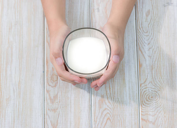 istock hand holding glass of milk 533574585