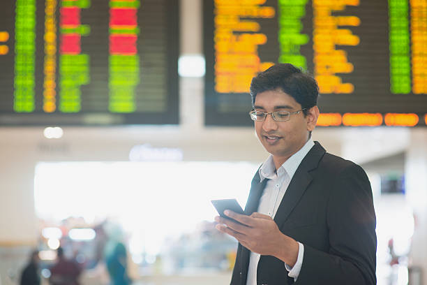 Web check in Asian Indian Business man checking on smartphone, doing online web check in at the airport . india airport stock pictures, royalty-free photos & images
