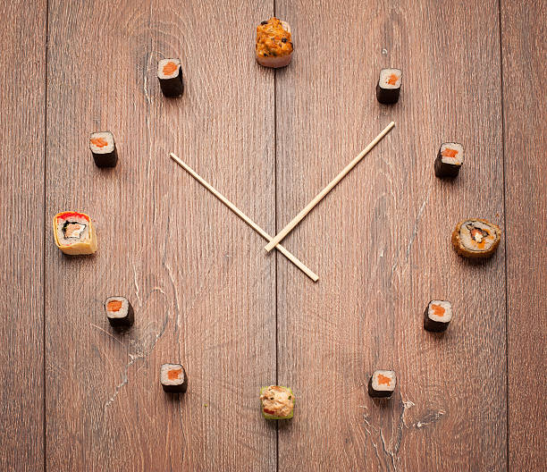 Sushi time in the form of a wall clock on a wooden background
