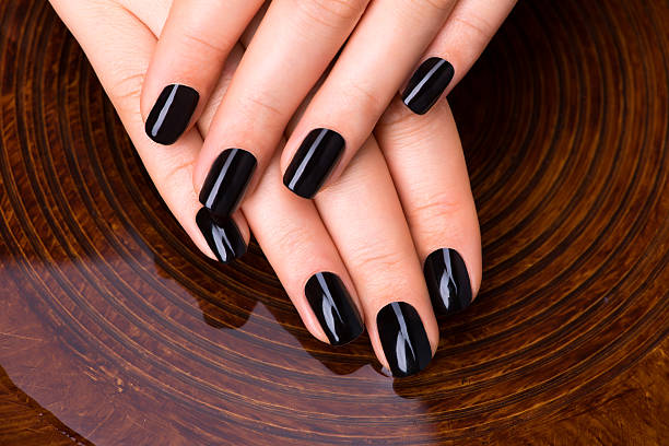 istock Beautiful women hands with black manicure 533575114