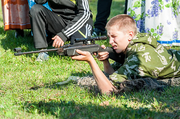 若い男性がエイム、空気銃 - armed forces human hand rifle bullet ストックフォトと画像