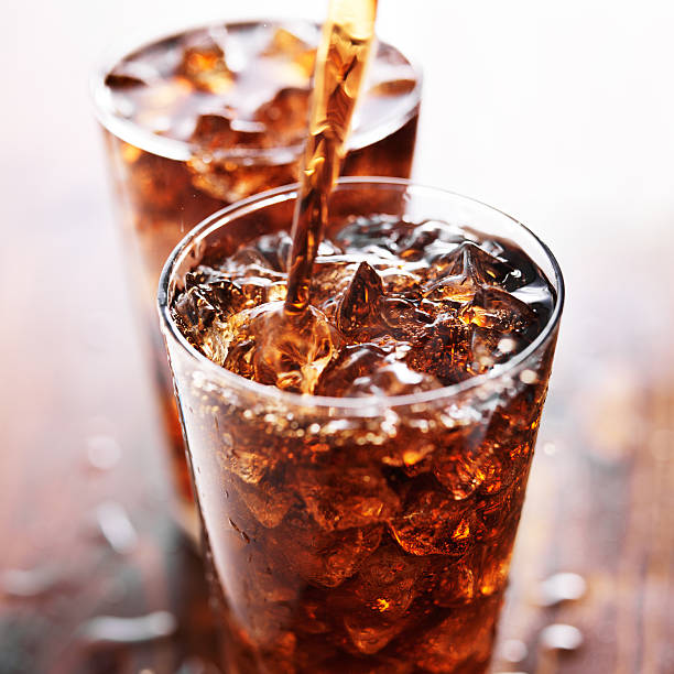 soft drink being poured into glass - koude dranken stockfoto's en -beelden