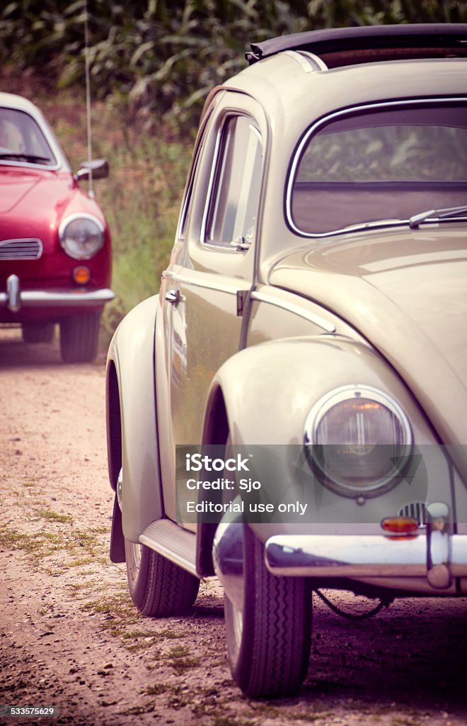 Two classic Volkswagen cars driving on a country road Lieren, The Netherlands - September 6, 2014: Volkswagen Beetle and Volkswagen Karmann Ghia driving in summer on a country road in near the village of Lieren in The Netherlands. 2015 Stock Photo