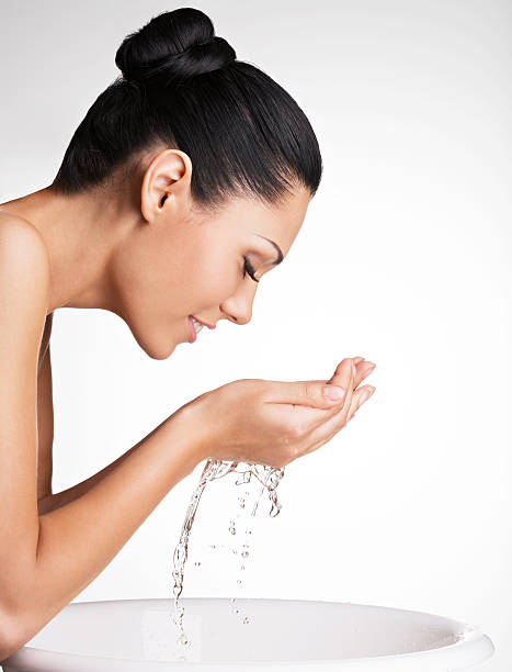 mujer sonriente lavándose la cara limpia con agua - human face water washing women fotografías e imágenes de stock