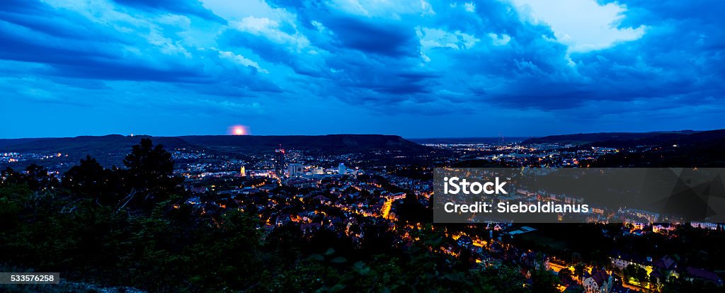 Panoramic photo of Jena (Thuringia, Germany) shortly after sunset. Panoramic photo of Jena (Thuringia, Germany) shortly after sunset. Visible landmarks are the Jentower, the Fuchsturm, the Zeiss factory and, far in the distance, Castle Leuchtenburg (illuminated). Black Color Stock Photo