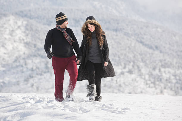 Happy couple walking on snow.